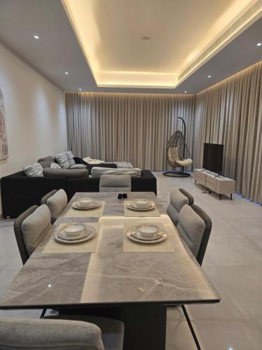 a living room with a table and a couch at Sukoon Wadi Alkhoud Stay in Seeb
