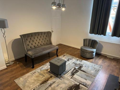 a living room with a chair and a stool at Poshval in Manchester