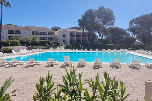 - une piscine avec des chaises longues et un bouquet dans l'établissement Chez K&D studio Soleil by Amel, à Saint-Raphaël
