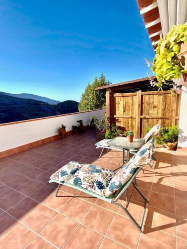 a patio with a table and chairs on a balcony at Ático puerta de la Alpujarra in Lanjarón