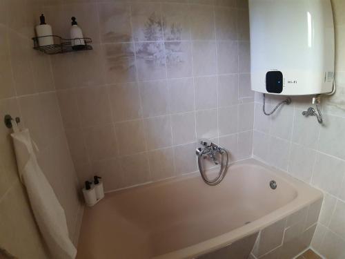a bathroom with a bath tub with a soap dispenser at Sunshine Vendégház Balatonfenyves in Balatonfenyves