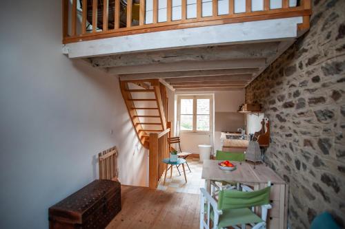 Cette chambre dispose d'un escalier et d'une table avec des chaises vertes. dans l'établissement Studio Triplex de Charme Bord de Rance, à Le Minihic-sur-Rance