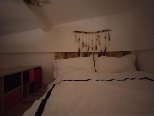 - une chambre avec un lit blanc et un rideau dans l'établissement Bohème dans le 5e, à Paris