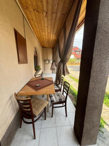 a wooden table and chairs on a patio at Anna Vendégház in Kápolnásnyék