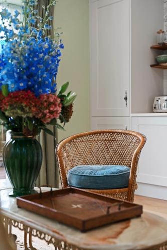 a table with a chair and a vase with flowers at 1 bed house in Hampshire in Chandlers Ford