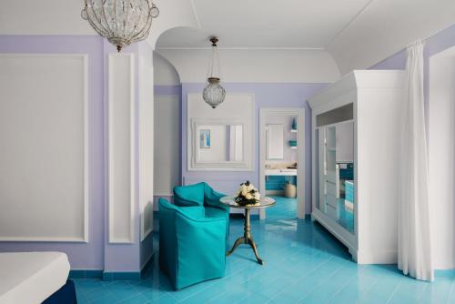 a blue and white room with a table and a chair at Bellevue Syrene in Sorrento