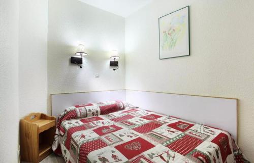 - une chambre avec un lit doté d'une couette rouge et blanche dans l'établissement Résidence La Licorne - maeva Home - Appartement 2 pièces 4 personnes - Confort MAE-9961, à La Plagne
