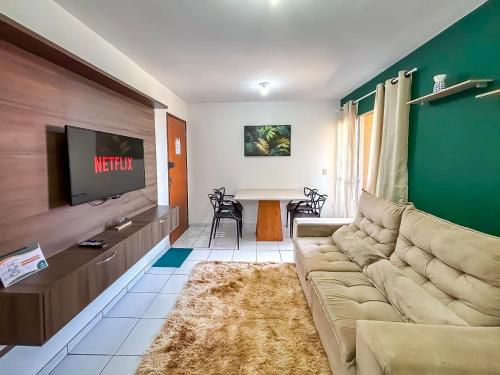 a living room with a couch and a tv at Apê Bela Vista com Piscina I Wi-Fi e A/C in Imperatriz