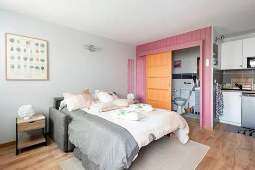 a bedroom with a large bed and a kitchen at Studio Clos-Edeen in Tréclun