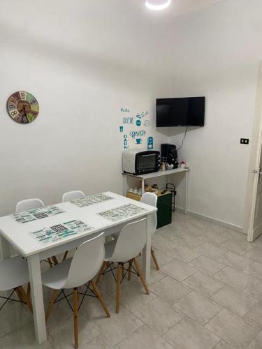 ein Esszimmer mit einem weißen Tisch und Stühlen in der Unterkunft BB casa vacanza in Catania