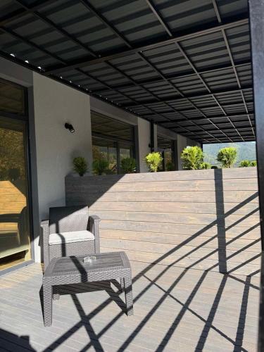 a patio with a chair and a table on a house at Готель WeLKoMe in Krivorovnya