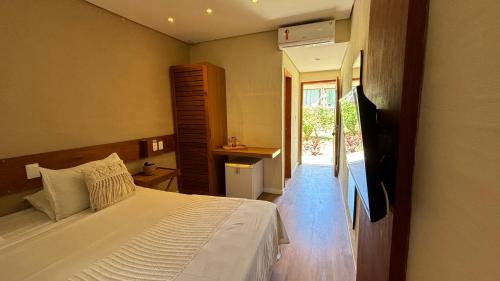 a bedroom with a bed and a door to a patio at Hotel da Pipa in Pipa