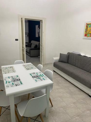 ein Wohnzimmer mit einem weißen Tisch und einer Couch in der Unterkunft BB casa vacanza in Catania