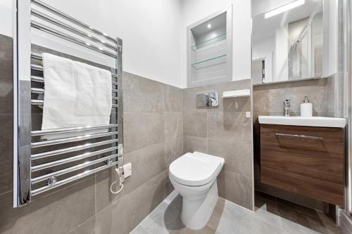 a bathroom with a toilet and a sink at Stylish Retreats on Olympic Way in London