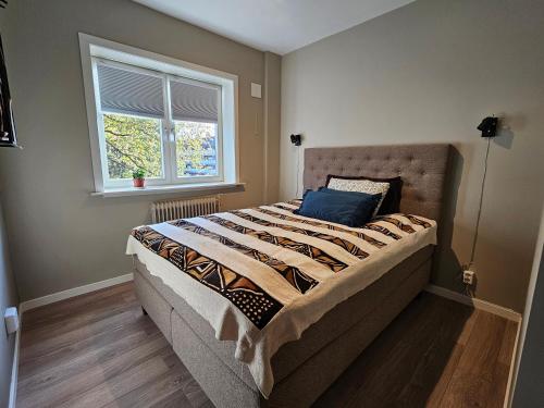 a large bed in a bedroom with a window at Koselig hjem nær Carl Berner in Oslo