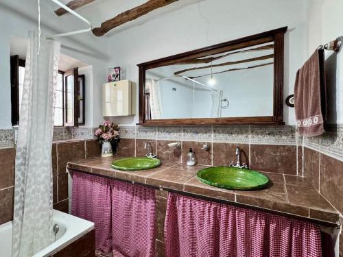 une salle de bain avec deux lavabos verts et un miroir dans l'établissement Cortijo Bernardino, à Chirivel