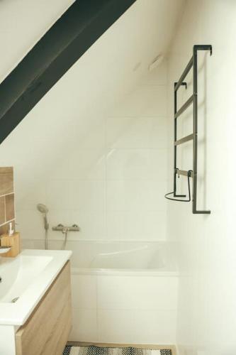 une salle de bain blanche avec un lavabo et une baignoire dans l'établissement maison en ville Karine et Flavie, à Flacé-lès-Mâcon