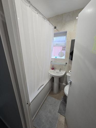 a bathroom with a shower and a toilet and a sink at Poshval in Manchester