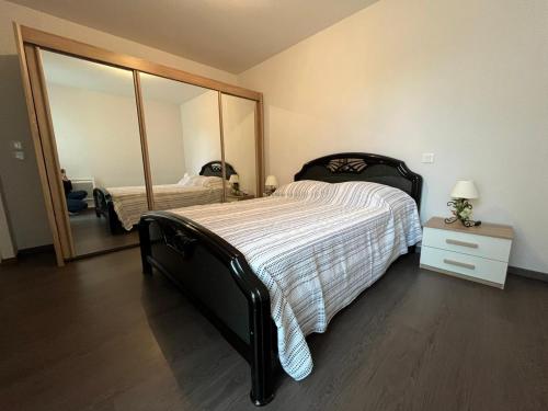 une chambre avec un grand lit et un grand miroir dans l'établissement Le Léman, à Thonon-les-Bains