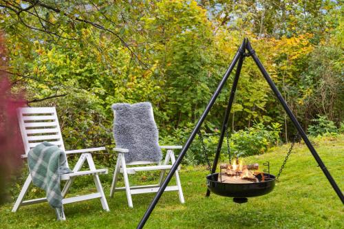 two chairs and a fire pit in the grass at Skrenten Apartment in Horten