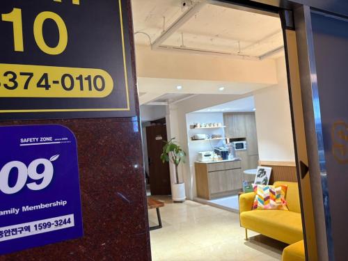 a store sign in a lobby with a yellow couch at stay110 in Seoul