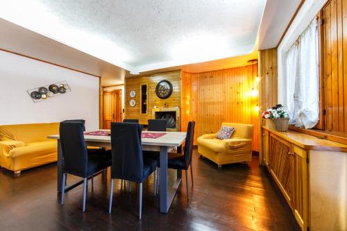 a dining room with a table and chairs and a couch at Residence Dei Medici-La casa nel parco in Pescasseroli