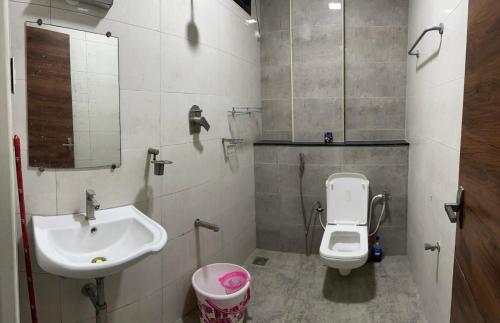a bathroom with a sink and a toilet and a mirror at Girivalam Vista Residency in Tiruvannāmalai