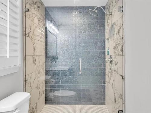 a shower with a glass door in a bathroom at Georgia Lakeside Getaway with Private Pool in Flowery Branch