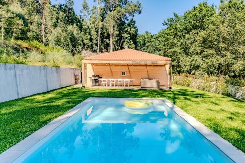 a swimming pool in a yard with a shed at Casa do Bosque in Vila Nova de Cerveira