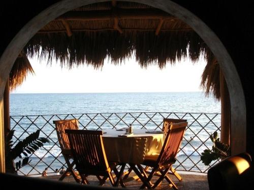 a table and chairs on a beach with the ocean at Vista al mar en Bucerías in Bucerías
