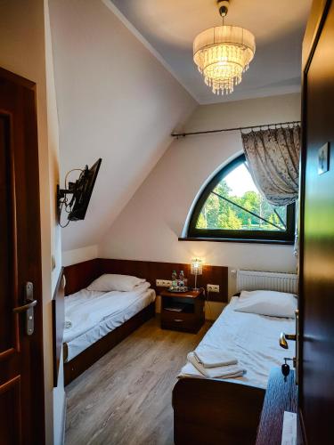a bedroom with two beds and a large window at Hotel Viwaldi in Baruchowo