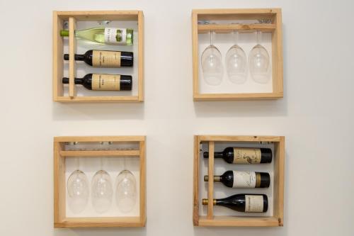 three pictures of wine bottles and glasses in a wall at Casa do Bosque in Vila Nova de Cerveira