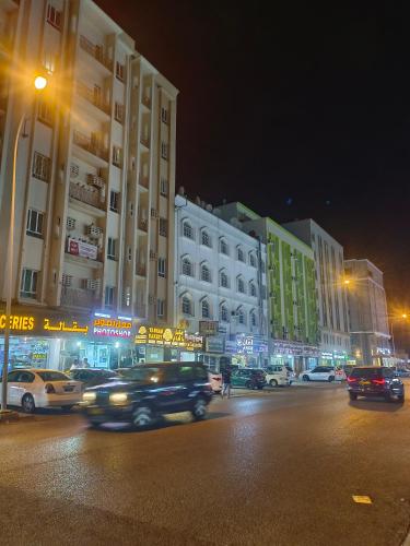 a city street at night with cars driving down the street at AL SHAMS MUSCAT MALE hostel in Muscat