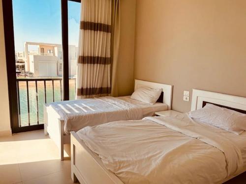 two beds in a room with a balcony at Sunset Haven in Tawila TownHouse in Hurghada