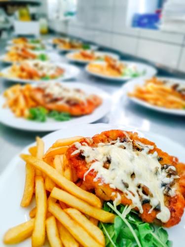 a table topped with plates of food with french fries at Hotel Viwaldi in Baruchowo