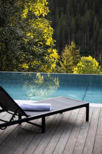 a chair sitting on a deck with a table at Paznauner Villen - Villa II in Kappl