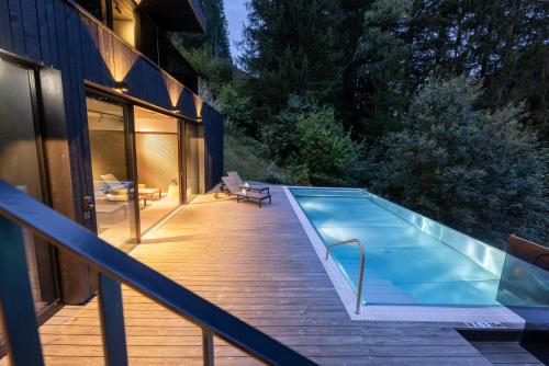 a swimming pool on a deck next to a house at Paznauner Villen - Villa II in Kappl
