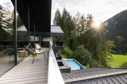 a house with a deck with a swimming pool at Paznauner Villen - Villa II in Kappl