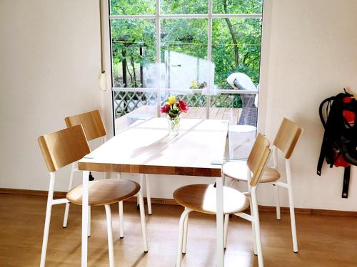 a dining room table with chairs and a vase of flowers at Beachbungalow in Karlshagen