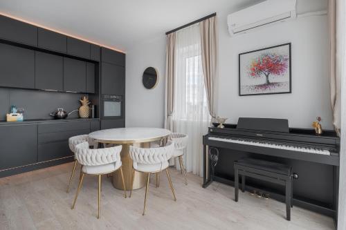 a kitchen with a table and a piano at Arena Gold Penthouse in Oradea