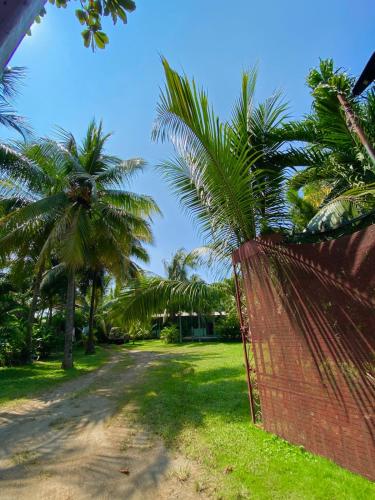 a red fence with palm trees behind it at The captains iin in Chinandega