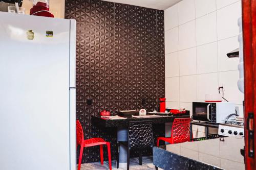 アライアル・ダジュダにあるIlha do Solのキッチン(テーブル、赤い椅子2脚付)