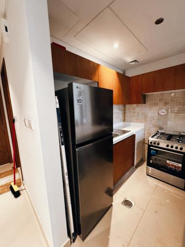 a kitchen with a stainless steel refrigerator and a stove at Al Reem Breeze in Abu Dhabi