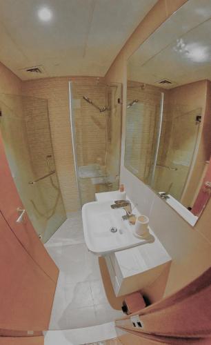 a bathroom with a sink and a shower at Al Reem Breeze in Abu Dhabi