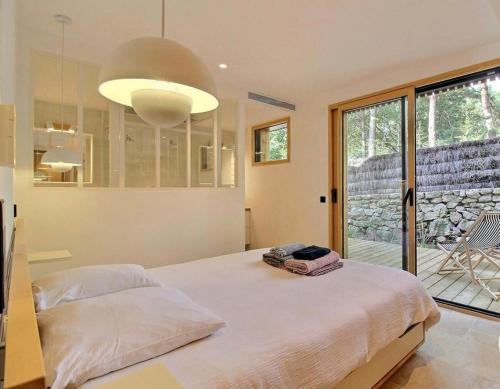 a bedroom with a large bed and a large window at Villa Namasté SPA Hammam port & Mer in La Trinité-sur-Mer