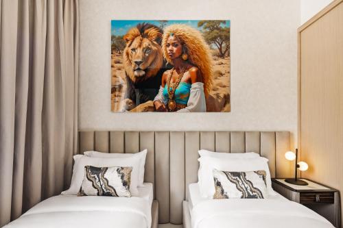 a bedroom with two beds and a painting of a woman and a lion at Modern Apartment in Dubai Creek Harbour By DuStay in Dubai