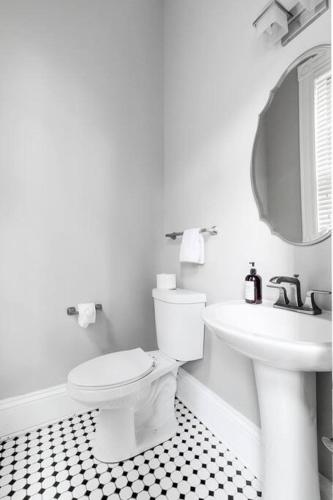 a white bathroom with a toilet and a sink at Luxury home in the historic Fan District in Richmond