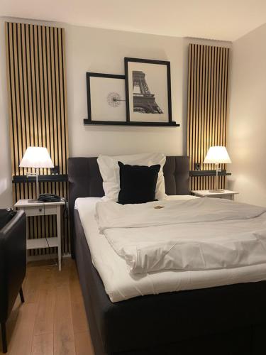 a bedroom with a large bed and two lamps at Steffens Herrnmuehle in Alzenau
