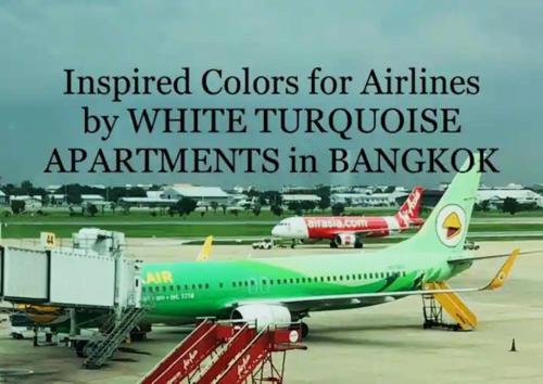 a green airplane parked on the runway at an airport at White Turquoise -2 Bedrooms Apartment- in Bangkok