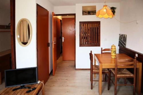 une salle à manger avec une table et une télévision dans l'établissement Résidence Le Belvedere - STUDIO N° 410 BELVEDERE MAE-4611, aux Orres